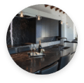 Modern kitchen featuring black limestone countertops and a wine glass.