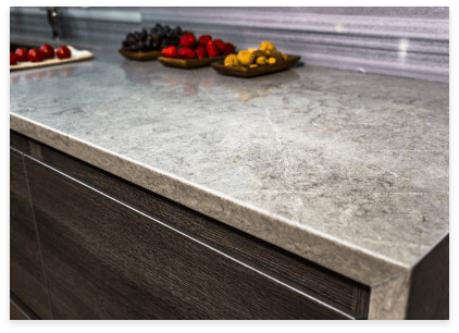Colorful fruit arranged on marble kitchen counter.
