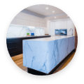 Stylish kitchen design with marble countertops and circular window.