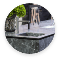 An elegant kitchen counter with onyx surfaces, showcasing a sink and a beautiful vase of flowers for a fresh touch.