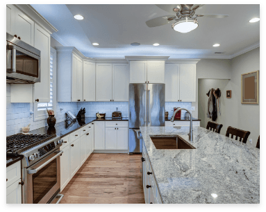A modern kitchen featuring white cabinets and a sleek marble countertop, emphasizing easy cleaning with granite surfaces.