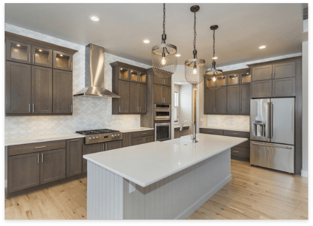 A modern white kitchen featuring a center island and sleek stainless steel appliances, creating a stylish cooking space.