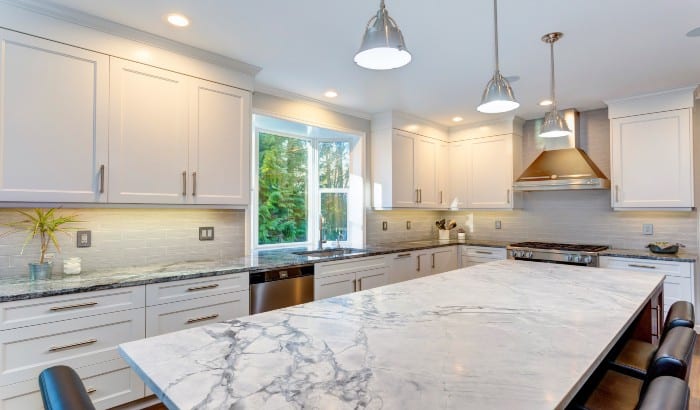 Elegant kitchen design with marble countertops and white cabinets.