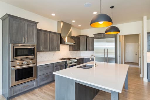A modern kitchen with sleek gray cabinets and stainless steel appliances.