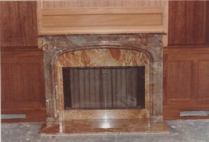 An elegant fireplace featuring a marble mantle and wood paneling, adding a touch of sophistication to the room.