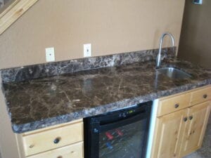 Modern kitchen counter with sleek sink and stainless steel refrigerator.