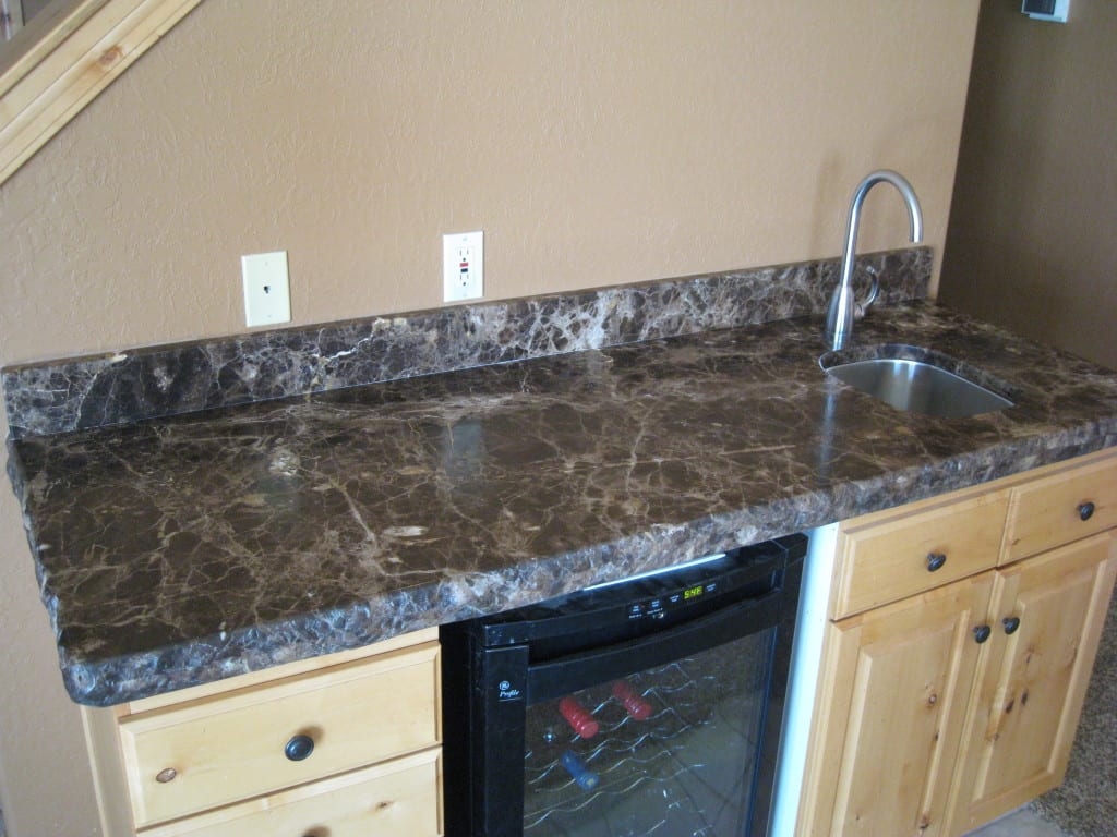 Modern kitchen counter with sleek sink and stainless steel refrigerator.