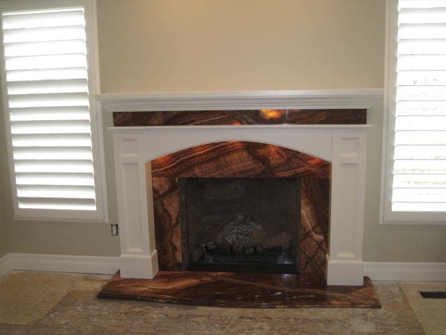 An inviting fireplace featuring a luxurious marble mantle, enhancing the room's ambiance.
