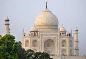Majestic white marble monument, the Taj Mahal, showcasing stunning architecture and surrounded by lush gardens.