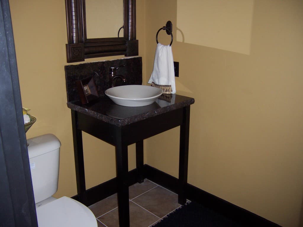 A modern bathroom with a sleek sink and a large mirror on the wall.