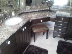 A bathroom with a vanity featuring a mirror and sink, accompanied by a stool for seating.