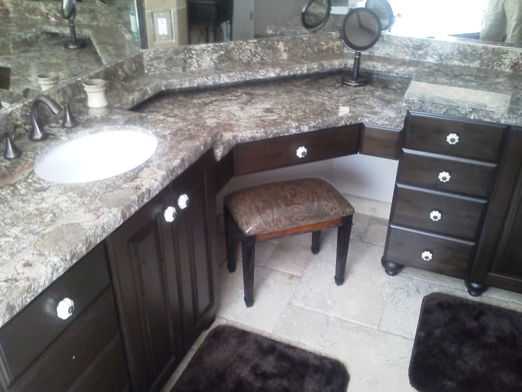A bathroom with a vanity featuring a mirror and sink, accompanied by a stool for seating.