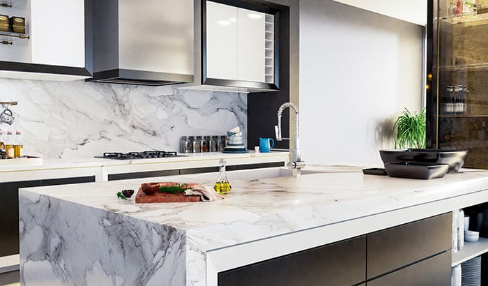 Modern kitchen with a marble island, featuring a cutting board with herbs and oil. Sleek cabinets and a plant add a stylish, minimalist vibe.