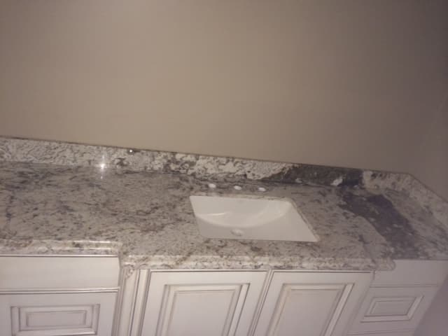 Bathroom with granite counter tops and sink.