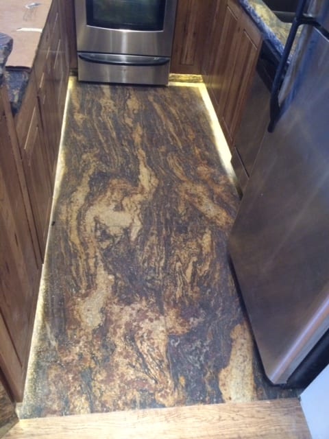 Sleek kitchen design with a leathered granite countertop, stainless steel appliances, and a sophisticated leathered granite floor.