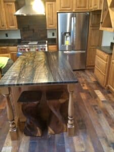 Large island and wooden flooring in a kitchen.