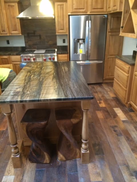 Large island and wooden flooring in a kitchen.