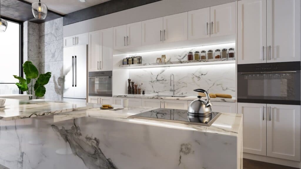 Modern kitchen with white cabinets, marble countertops, and stainless steel appliances.