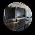 Modern kitchen featuring black limestone countertops and a wine glass.