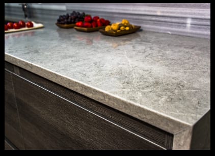Colorful fruit arranged on marble kitchen counter.
