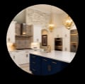 Blue kitchen cabinets with white granite countertops.