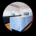 Stylish kitchen design with marble countertops and circular window.