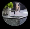 An elegant kitchen counter with onyx surfaces, showcasing a sink and a beautiful vase of flowers for a fresh touch.